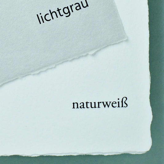 Detail handgeschöpftes Büttenpapier Farbvergleich lichtgrau auf naturweiß